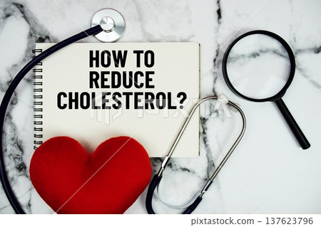 How To Reduce Cholesterol? text written on notepad with red heard and stethoscope on marble background How To Reduce Cholesterol? text written on notepad with red heard and stethoscope on marble background 137623796