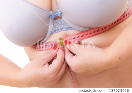 Woman plus size measuring her chest under breasts Woman plus size measuring her chest under breasts 137623966