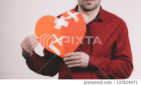 Man holding broken heart. Heartbreak Man holding broken heart. Heartbreak 137624471