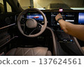 A driver uses a touchscreen in a modern car. 137624561