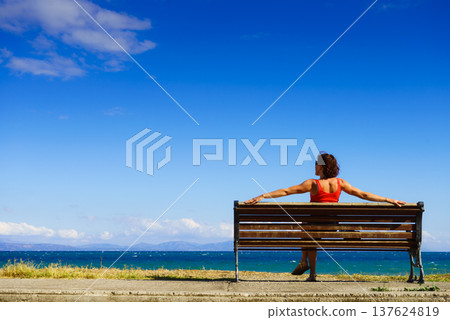 Tourist woman on bench enjoying sea view Tourist woman on bench enjoying sea view 137624819