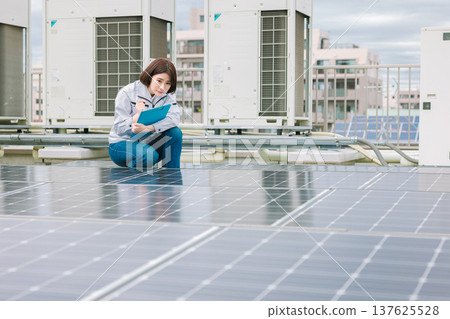 檢查太陽能電池板的女工 檢查太陽能電池板的女工 137625528