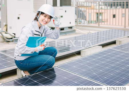 Female worker inspecting solar panels 137625530