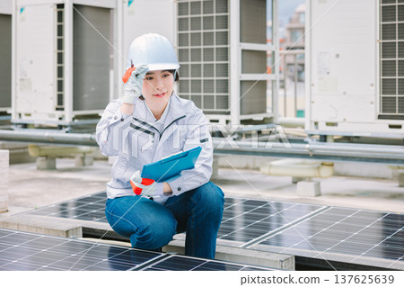 檢查太陽能電池板的女工 檢查太陽能電池板的女工 137625639