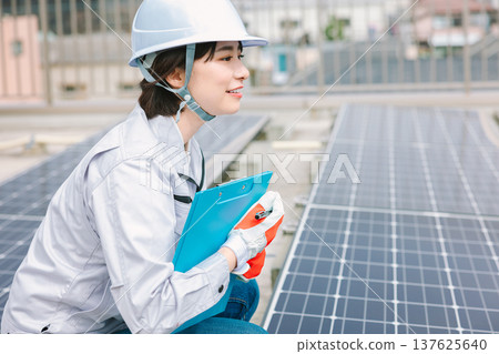 檢查太陽能電池板的女工 檢查太陽能電池板的女工 137625640