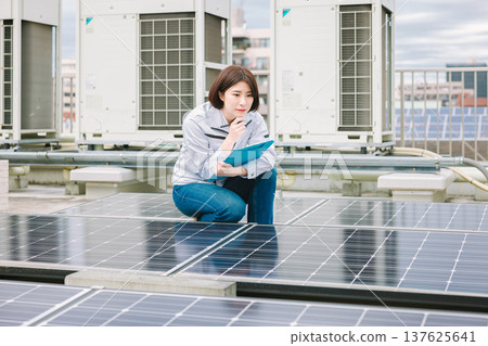 Female worker inspecting solar panels 137625641