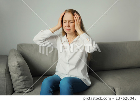 Exhausted tired woman suffering from headache, stress, fatigue, temples pain, migraine, loud noise 137626045