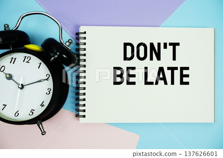 Don't Be Late text written on notepad with alarm clock flat lay on multicolor pastel background Don't Be Late text written on notepad with alarm clock flat lay on multicolor pastel background 137626601