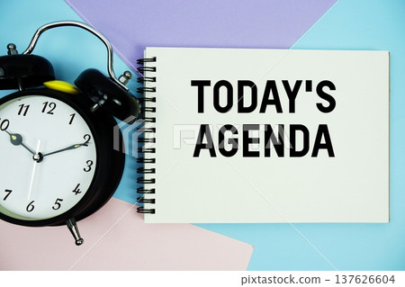 Today's Agenda text written on notepad with alarm clock flat lay on multicolor pastel background Today's Agenda text written on notepad with alarm clock flat lay on multicolor pastel background 137626604