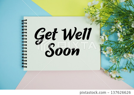 Get Well Soon text written on notepad with flowers decorations flat lay on multicolor pastel background Get Well Soon text written on notepad with flowers decorations flat lay on multicolor pastel background 137626626