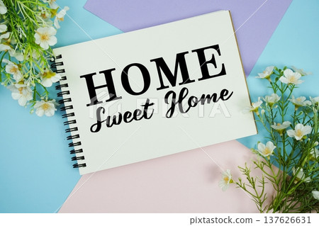 Home Sweet Home text written on notepad with flowers decorations flat lay on multicolor pastel background Home Sweet Home text written on notepad with flowers decorations flat lay on multicolor pastel background 137626631