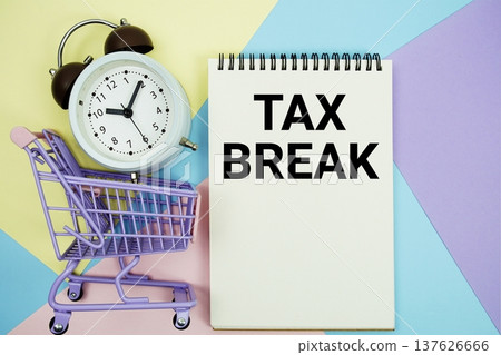 Tax Break text written on notepad with alarm clock and trolley shopping cart Tax Break text written on notepad with alarm clock and trolley shopping cart 137626666
