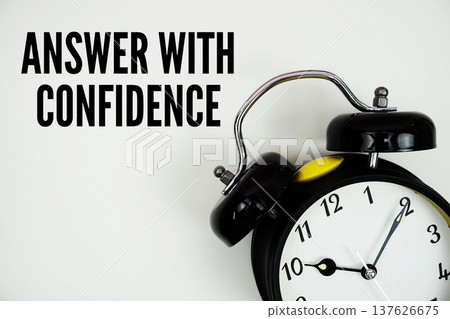 Answer With Confidence text with alarm clock flat lay on white background Answer With Confidence text with alarm clock flat lay on white background 137626675