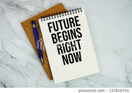 Future Begins Right Now text written on notepad with pen on marble background Future Begins Right Now text written on notepad with pen on marble background 137626704