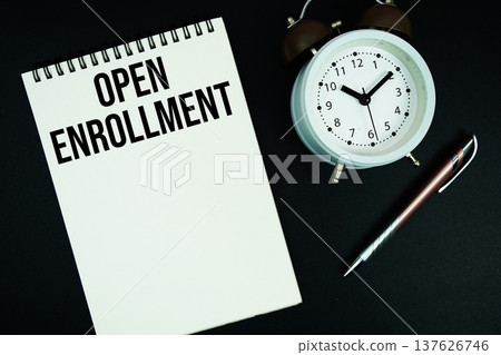 Open Enrollment text written on notepad with pen and alarm clock 137626746