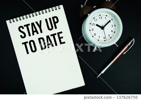 Stay Up To Date text written on notepad with pen and alarm clock Stay Up To Date text written on notepad with pen and alarm clock 137626750