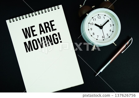 We Are Moving text written on notepad with pen and alarm clock We Are Moving text written on notepad with pen and alarm clock 137626756