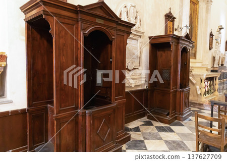 Wooden confession booths inside catholic church interior Wooden confession booths inside catholic church interior 137627709