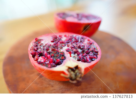 Pomegranate is cut in half on wooden surface. Fresh pomegranate Pomegranate is cut in half on wooden surface. Fresh pomegranate 137627813