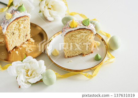 Cutted Easter Cake with Flowers and Pastel Eggs on White Background Cutted Easter Cake with Flowers and Pastel Eggs on White Background 137631019