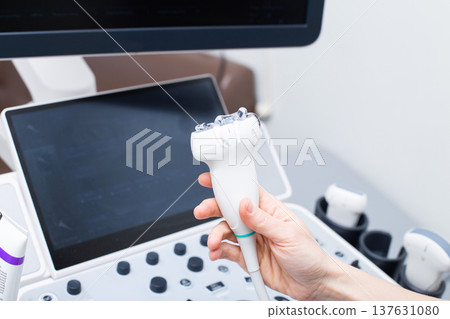 Woman doctor's hand aholding a medical gel to ultrasonic sensor of ultrasound machine in the clinic 137631080