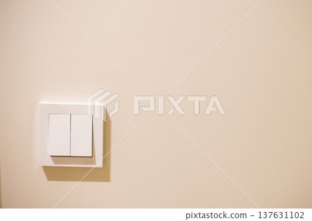 White modern light switch on beige interior wall White modern light switch on beige interior wall 137631102