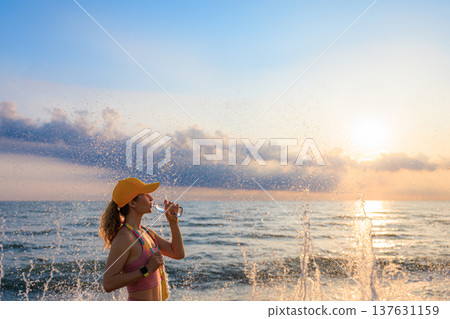Fit woman jumping rope at the beach during summer vacation Fit woman jumping rope at the beach during summer vacation 137631159