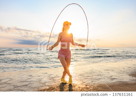 Fit woman jumping rope at the beach during summer vacation 137631161