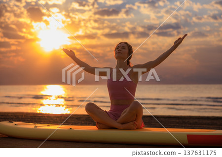 Athlete woman practicing yoga at the beach during summer vacation. Slow motion Athlete woman practicing yoga at the beach during summer vacation. Slow motion 137631175