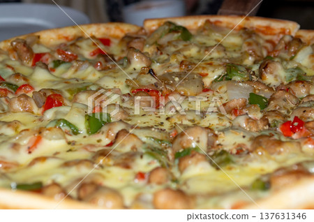 Cheesy pizza with chicken, mushrooms and bell peppers close-up 137631346
