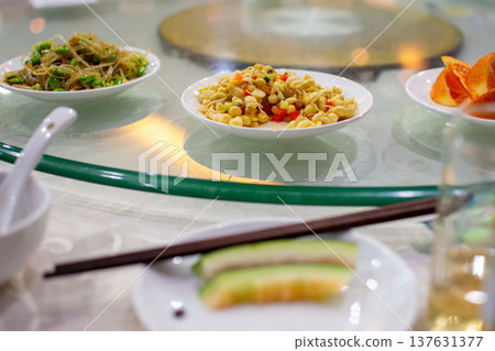 Chinese restaurant table with dishes on glass lazy susan 137631377