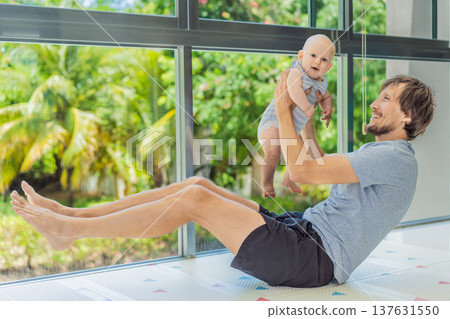 Father exercising with his small baby at home, active parenting and healthy lifestyle. Strong family bond, early physical development, modern fatherhood, fitness with children concept. 137631550