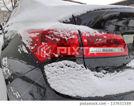 The red rear light of the black car is covered in snow The red rear light of the black car is covered in snow 137631589
