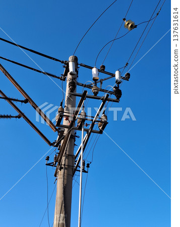 Wires, insulators and electrical equipment on a pole near railway tracks Wires, insulators and electrical equipment on a pole near railway tracks 137631614