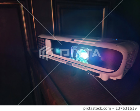 Movie is shown through projector. Light of blue color passes through lenses Movie is shown through projector. Light of blue color passes through lenses 137631619