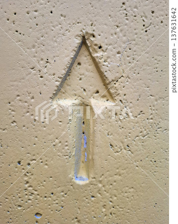An upward-pointing arrow pressed into yellow-painted concrete An upward-pointing arrow pressed into yellow-painted concrete 137631642