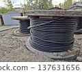 Black cables in heavy spools are laid for the power grid 137631656