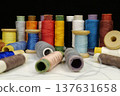 Spools with multi-colored threads on black background, close-up shot 137631658