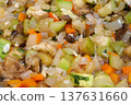 Vegetable stew is cooked on gas stove in metal pan. Vegetable ragout 137631660