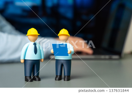 Two engineers in hard hats and holding blueprints. Architecture planning and construction management. Engineering teamwork in building projects, infrastructure development and professional design Two engineers in hard hats and holding blueprints. Architecture planning and construction management. Engineering teamwork in building projects, infrastructure development and professional design 137631844