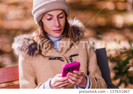 woman with eating disorders using smartphone outdoors during autumn season woman with eating disorders using smartphone outdoors during autumn season 137631967