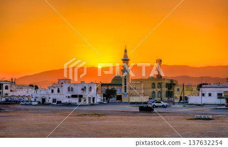 Golden sunset glow illuminates Aisha Makha Mosque and traditional Omani architecture in the coastal city of Sur in Oman Golden sunset glow illuminates Aisha Makha Mosque and traditional Omani architecture in the coastal city of Sur in Oman 137632254