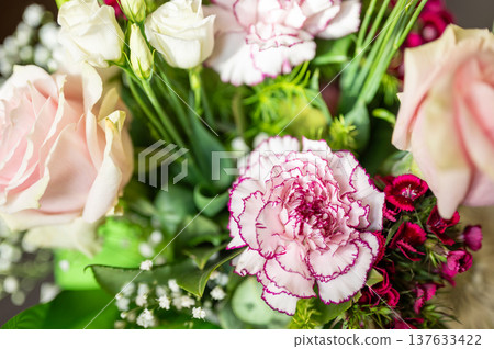 Beautiful flower bouquet showcasing a variety of pink and white blooms including carnations, roses, and baby's breath, arranged with fresh green foliage creating a soft, celebratory display Beautiful flower bouquet showcasing a variety of pink and white blooms including carnations, roses, and baby's breath, arranged with fresh green foliage creating a soft, celebratory display 137633422