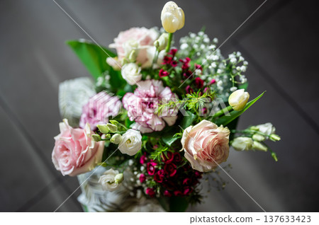Elegant floral bouquet presenting various pale pink, white, and red flowers with green foliage, creating a romantic and festive arrangement for celebration or a special occasion 137633423