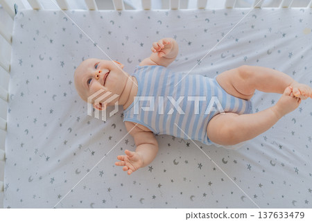 Baby lying peacefully in a cozy crib at home, feeling safe and calm in a warm nursery atmosphere. Simple everyday moment of care and comfort. Infant sleep, early childhood and gentle parenting concept Baby lying peacefully in a cozy crib at home, feeling safe and calm in a warm nursery atmosphere. Simple everyday moment of care and comfort. Infant sleep, early childhood and gentle parenting concept 137633479