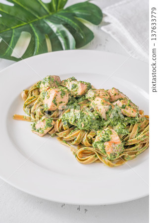 Whole grain tagliatelle pasta with salmon spinach in creamy sauce gourmet dish 137633779