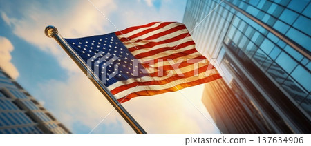 A vibrant flag gracefully billowing in the wind against a majestic building backdrop under a clear blue sky. 137634906
