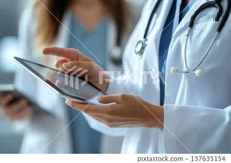 Doctor Utilizing Tablet Computer in Hospital Environment to Enhance Patient Care and Streamline Medical Processes Doctor Utilizing Tablet Computer in Hospital Environment to Enhance Patient Care and Streamline Medical Processes 137635154