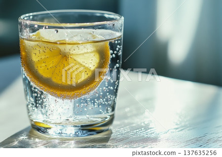 Refreshing Glass of Lemon Water with a Slice of Lemon Garnish on a Wooden Table Surface 137635256