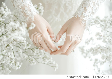 Romantic Bride in Elegant Wedding Dress Holding a Shimmering Engagement Ring Under Soft Natural Lighting Romantic Bride in Elegant Wedding Dress Holding a Shimmering Engagement Ring Under Soft Natural Lighting 137635284